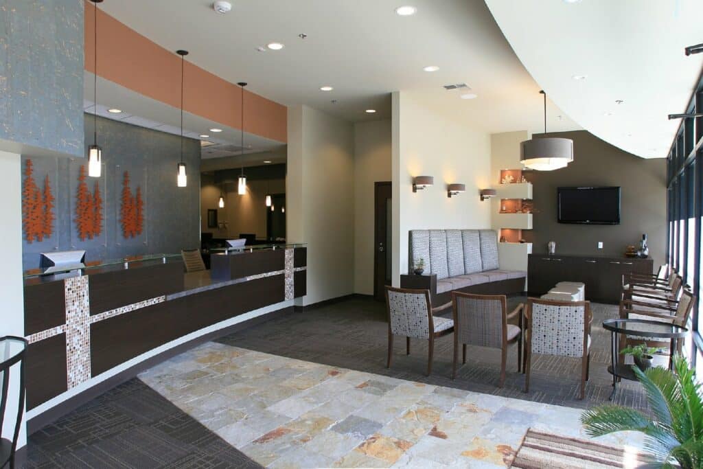 Modern dental office reception area with front desk, waiting seating, and contemporary interior design.